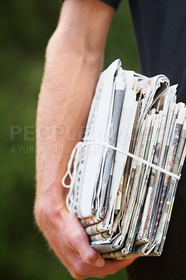 Buy stock photo Closeup, stack and man with newspaper, delivery and daily information with stories, courier and bundle. Zoom, male person and hand with journalism, recycle paper and distribution with sustainability