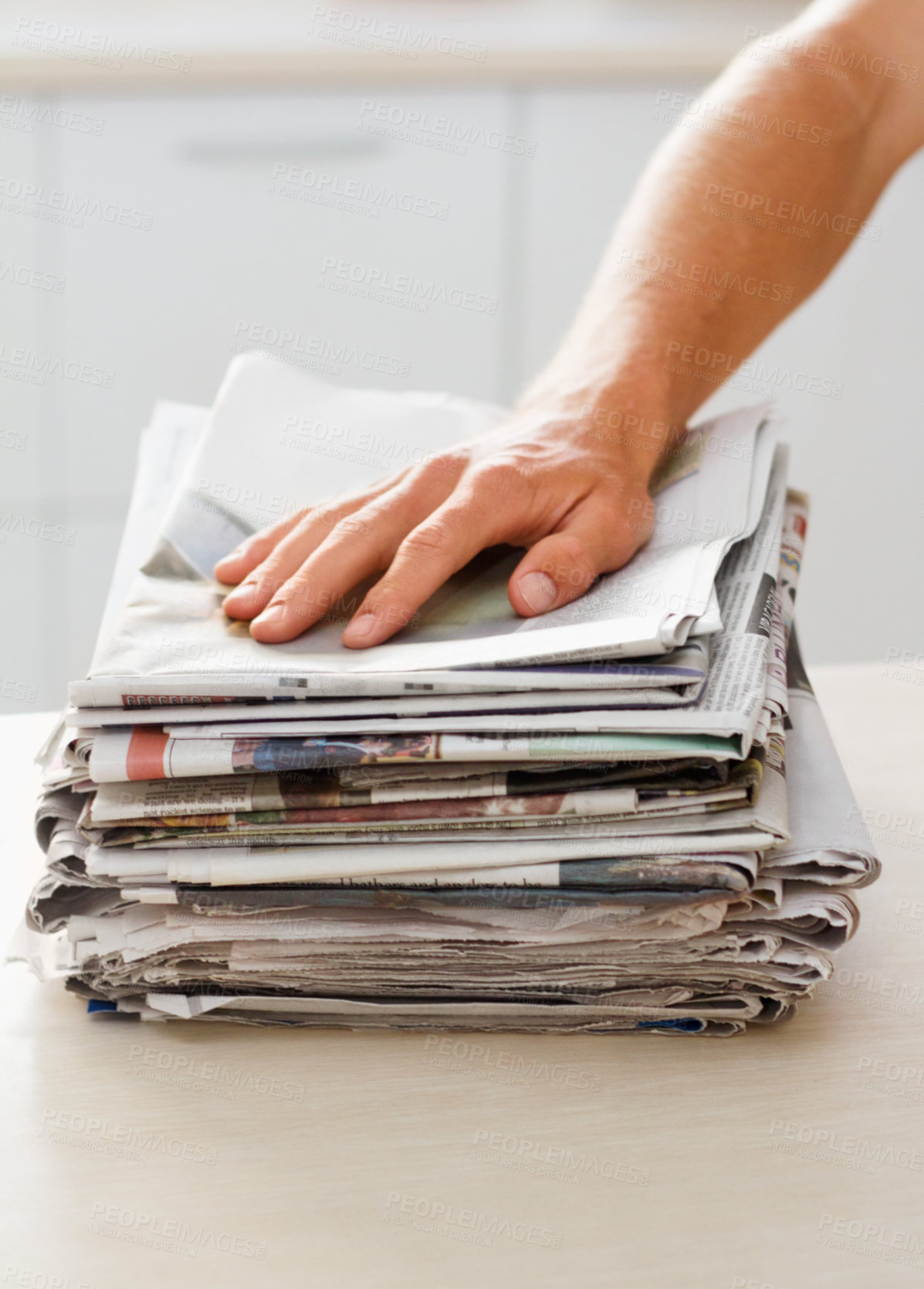 Buy stock photo Cropped shot of a man with a stack of newspaper