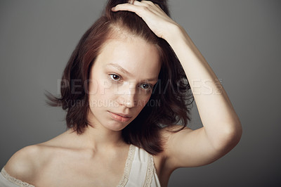 Buy stock photo Sad woman, stress and anxiety with hand on hair in mental health problem isolated on a grey studio background. Anxious, stressed or depressed young female model holding head in thought on backdrop