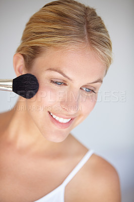 Buy stock photo Closeup shot of an attractive young woman applying makeup with a brush