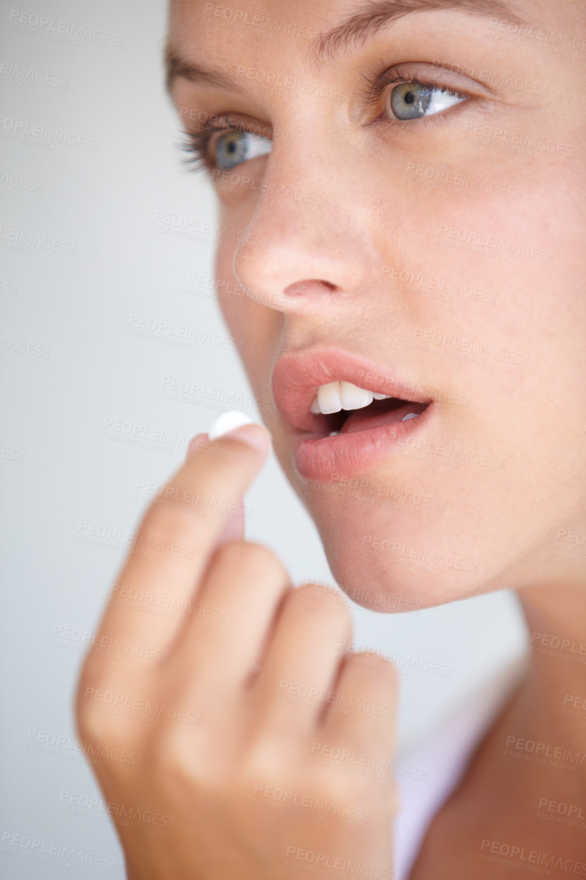 Buy stock photo Closeup shot of a young woman taking a vitamin