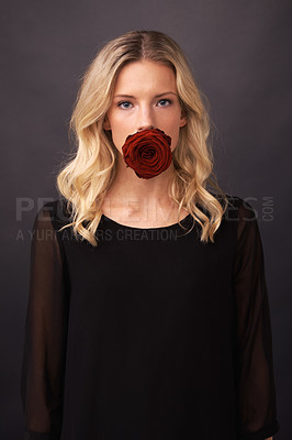 Buy stock photo Conceptual image of a blonde woman with a rose covering her mouth
