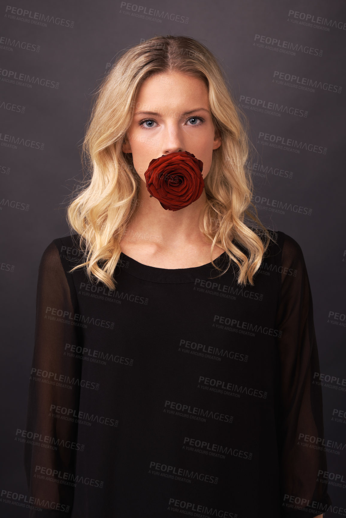 Buy stock photo Conceptual image of a blonde woman with a rose covering her mouth