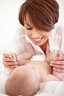 Buy stock photo Mother, baby and playing or love, care and relaxing on bed, bonding and joy in parenthood. Mom, newborn and peace or calm at home, positive and happy for child development, smile and fun together