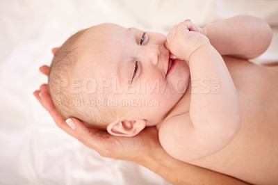 Buy stock photo Happy, baby on bed and hands of parent with love, trust and care for child in home together. Kid smile, infant and closeup in bedroom, nursery and bonding for growth, family support and suck thumb