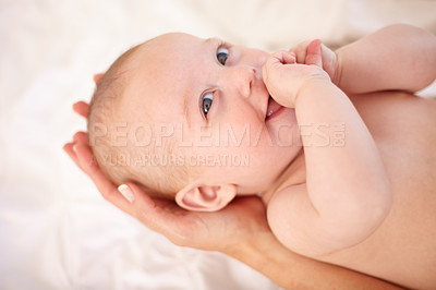 Buy stock photo Smile, baby on bed and hands of parent with love, trust and care for child in home together. Happy kid, infant and closeup in bedroom, nursery and bonding for growth, development and family support