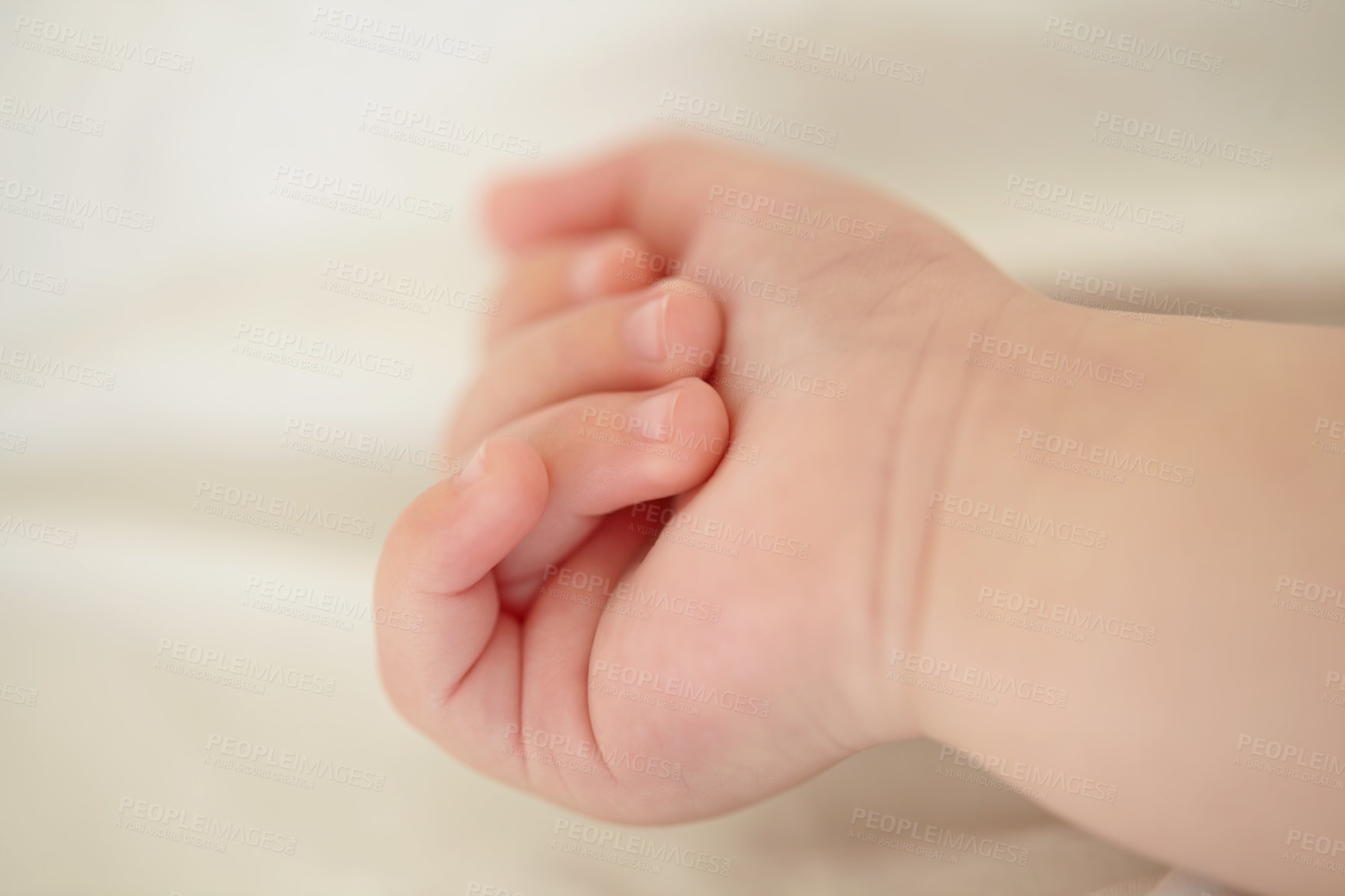 Buy stock photo Relax, development and the hand of a baby closeup in a nursery or bedroom of a home for rest at bedtime. Kids, sleeping or wellness with the fist and fingers of a newborn infant child lying on a bed