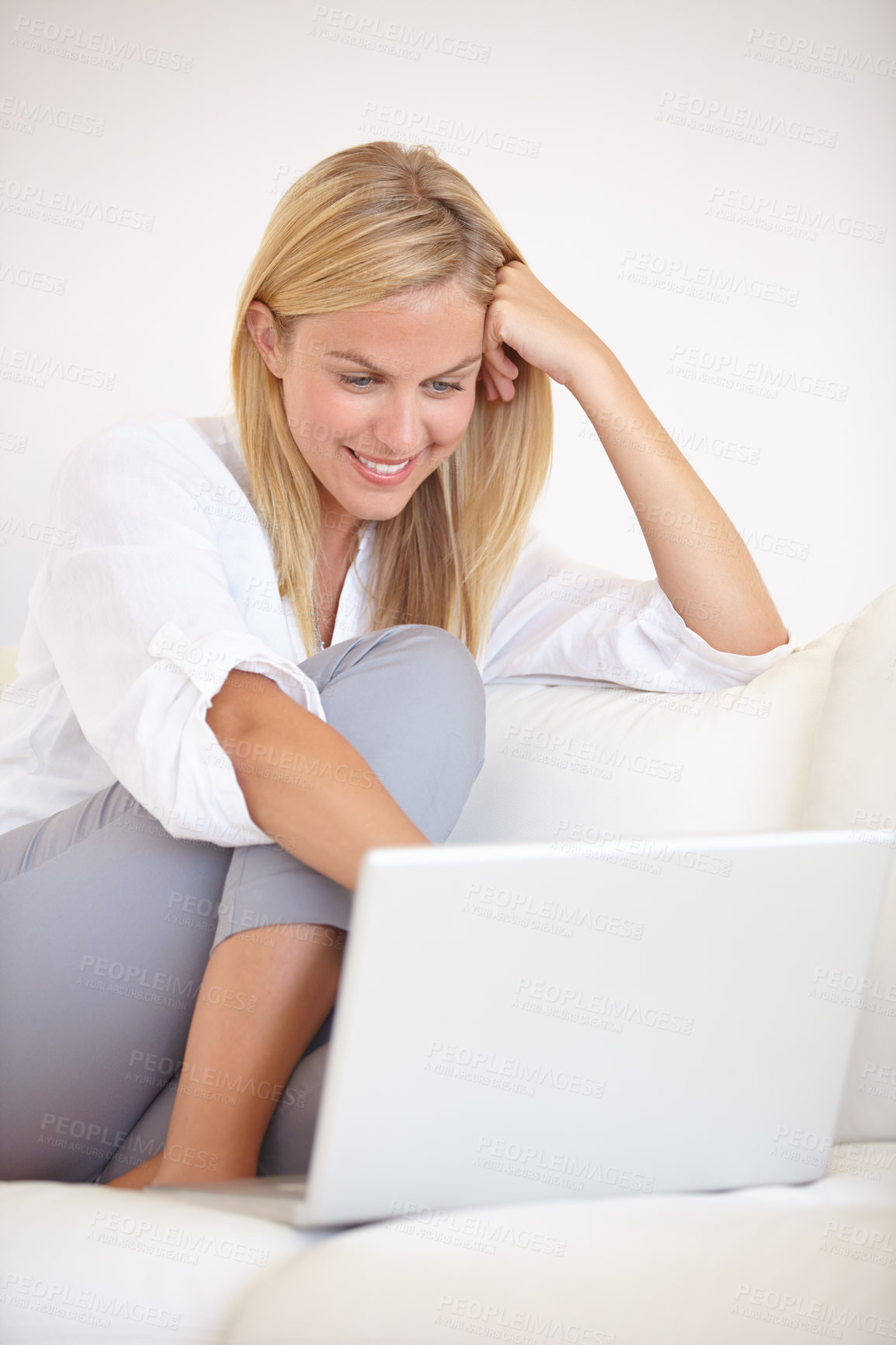 Buy stock photo A gorgeous young woman working on her laptop while sitting on the couch