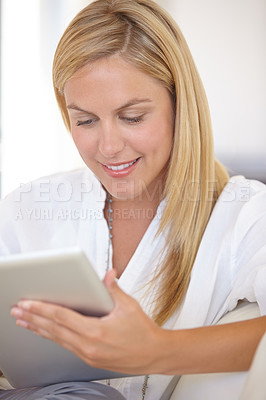 Buy stock photo A beautiful young blonde woman working on her digital touchpad