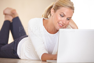 Buy stock photo Home, laptop and woman on the floor, typing and communication with a smile, website info and relax. Person, apartment and girl with technology, connection and digital app with internet and network