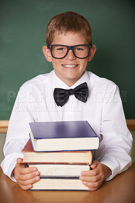 Buy stock photo Boy child, smile and portrait with books, classroom and learning for exam, assessment and studying for knowledge. Student kid, notebook and happy for education, development and glasses at table
