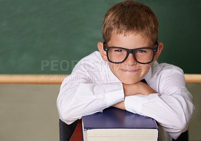 Buy stock photo Happy boy, portrait and relax on books at school for learning, education or knowledge with green chalk board. Face of male person, smart child or young teenager smile for academic literature in class