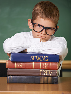Buy stock photo Frustrated boy child, books and portrait in classroom for knowledge, information and studying at academy. Student kid, learning and education with glasses, angry and stress for assessment at school