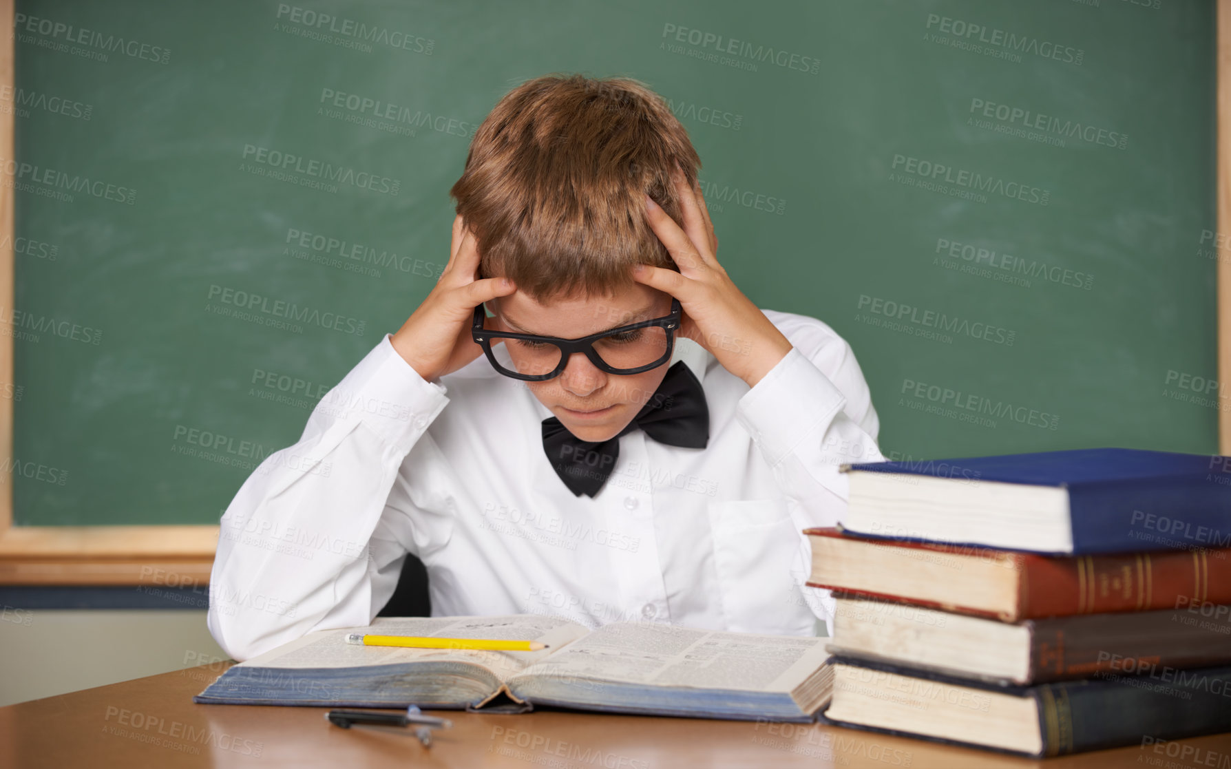Buy stock photo Boy child, stress and thinking with books, classroom and anxiety for exam, assessment and studying for knowledge. Student kid, notebook and learning for education, development and reading at table