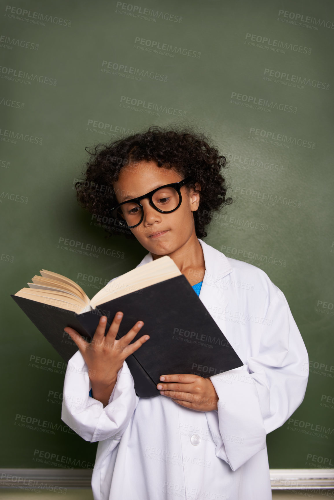 Buy stock photo Child, classroom and reading book for education, science learning and physics knowledge on a chalkboard background. Kid or young student with glasses for library resources, textbook and school