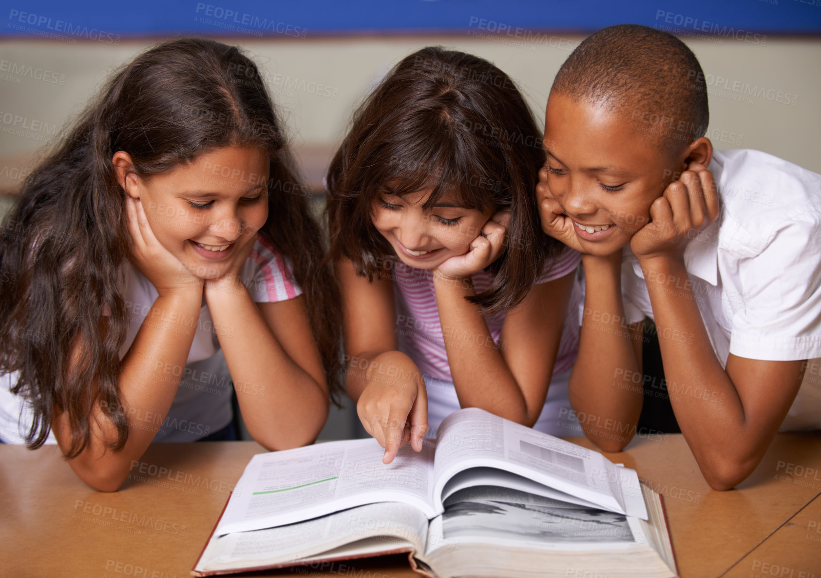 Buy stock photo School kids, reading and happy in classroom with book, pointing and thinking with learning, diversity or info. Children, development and education with friends, students and smile for assessment