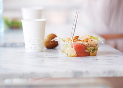 Buy stock photo Lunch, salad and healthy food on table in office with fruit and drink for energy, nutrition or diet. Paper cup, apple and plastic container in cafeteria, buffet with fork for meal with vegetables