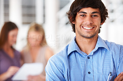 Buy stock photo Shot of a leader smiling at the camera with colleagues blurred in the background