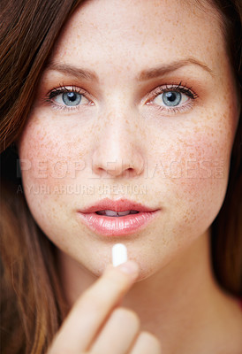 Buy stock photo Portrait of an attractive young woman taking some medication
