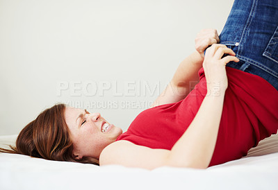 Buy stock photo A young woman trying to fit into her jeans