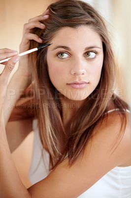 Buy stock photo An attractive young woman applying eyeliner