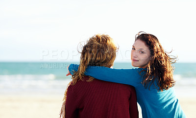 Buy stock photo Rearview portrait of two sisters sitting at the beach