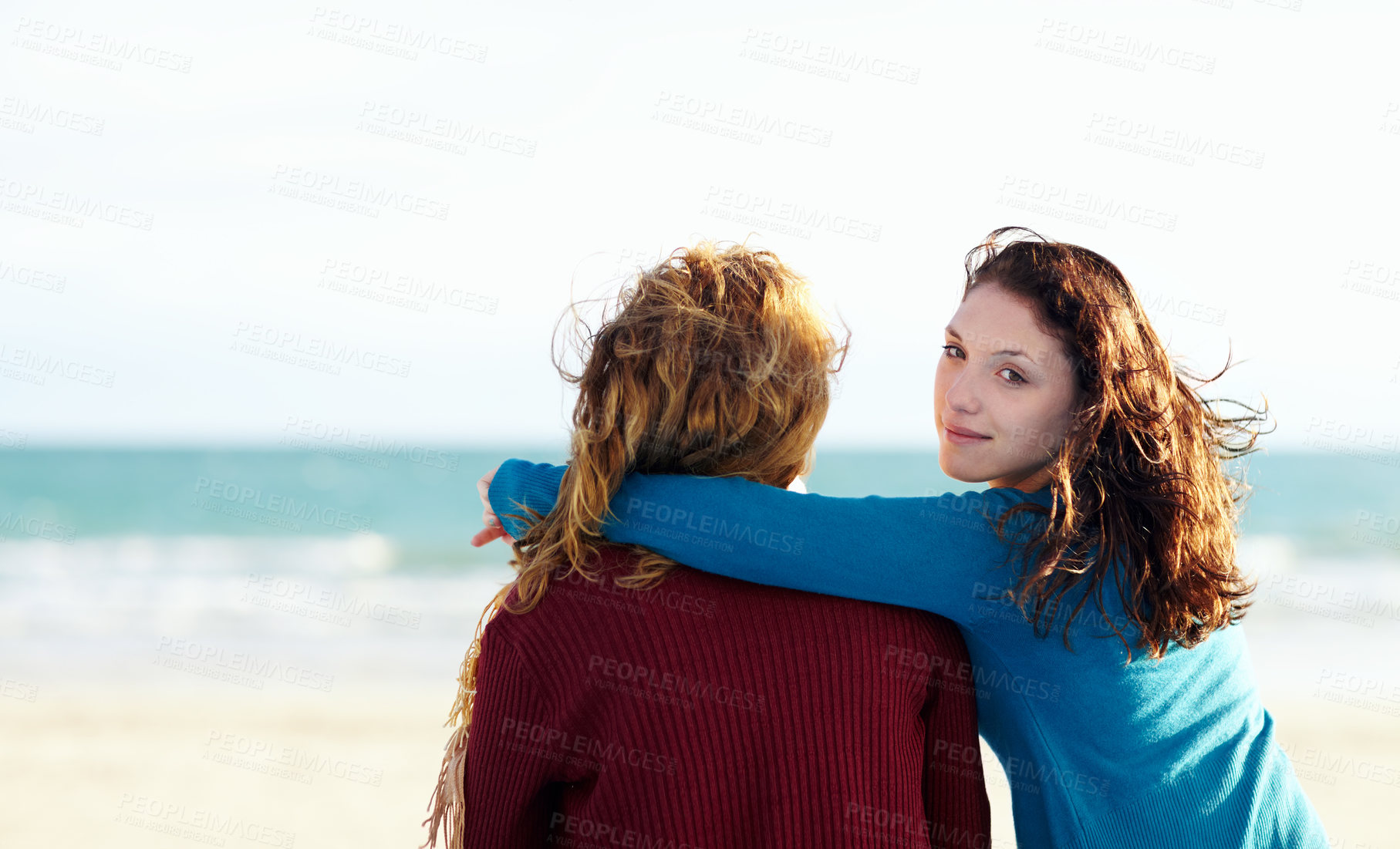Buy stock photo Rearview portrait of two sisters sitting at the beach