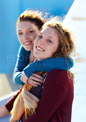 Buy stock photo Portrait of two sister's sitting outside and embracing warmly