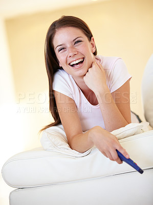 Buy stock photo Smile, laughing and a woman watching tv on a sofa in the living room of her home for entertainment. Relax, funny and streaming with a happy young person holding a remote for a television subscription
