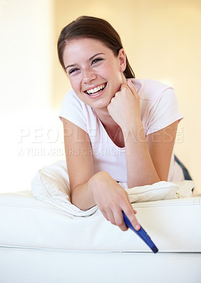 Buy stock photo Smile, funny and a woman watching tv on a sofa in the living room of her home for entertainment. Relax, laughing and streaming with a happy young person holding a remote for a television subscription