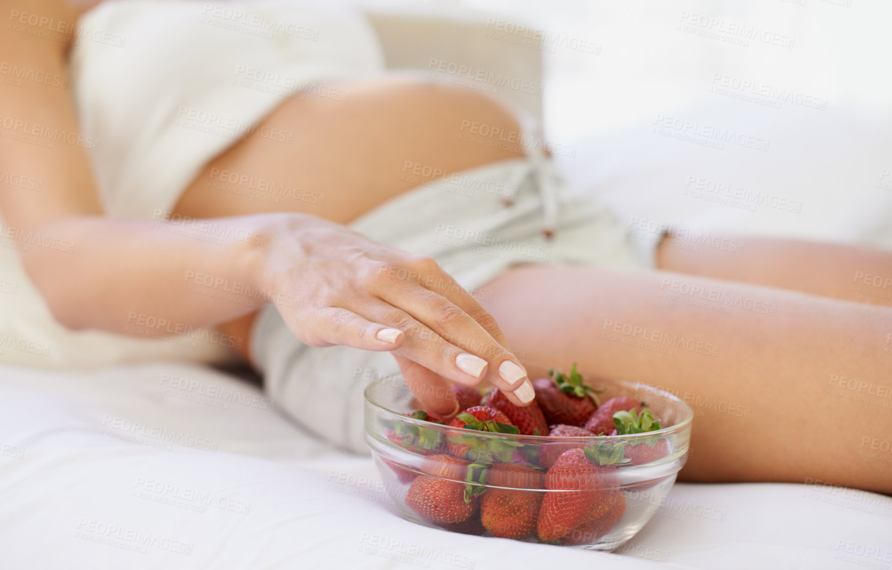 Buy stock photo Cropped image of a pregnant woman with a bowl of strawberries