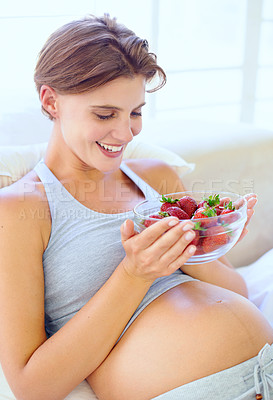 Buy stock photo Pregnant woman, strawberry and nutrition in bedroom with relax wellness for eating fruit in house. Young person, happy and prenatal health diet with natural food for vitamins and care in apartment
