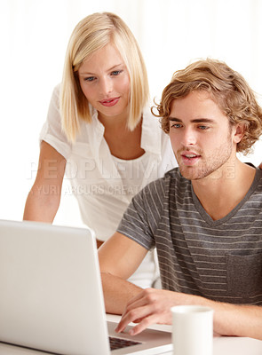 Buy stock photo A handsome young man showing his girlfriend something on his laptop