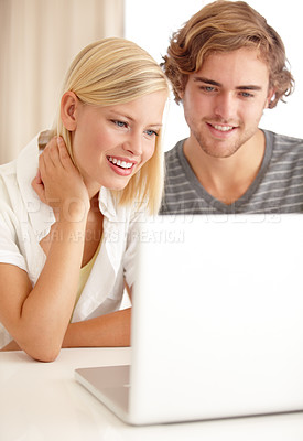Buy stock photo A happy young couple using a laptop to browse the net