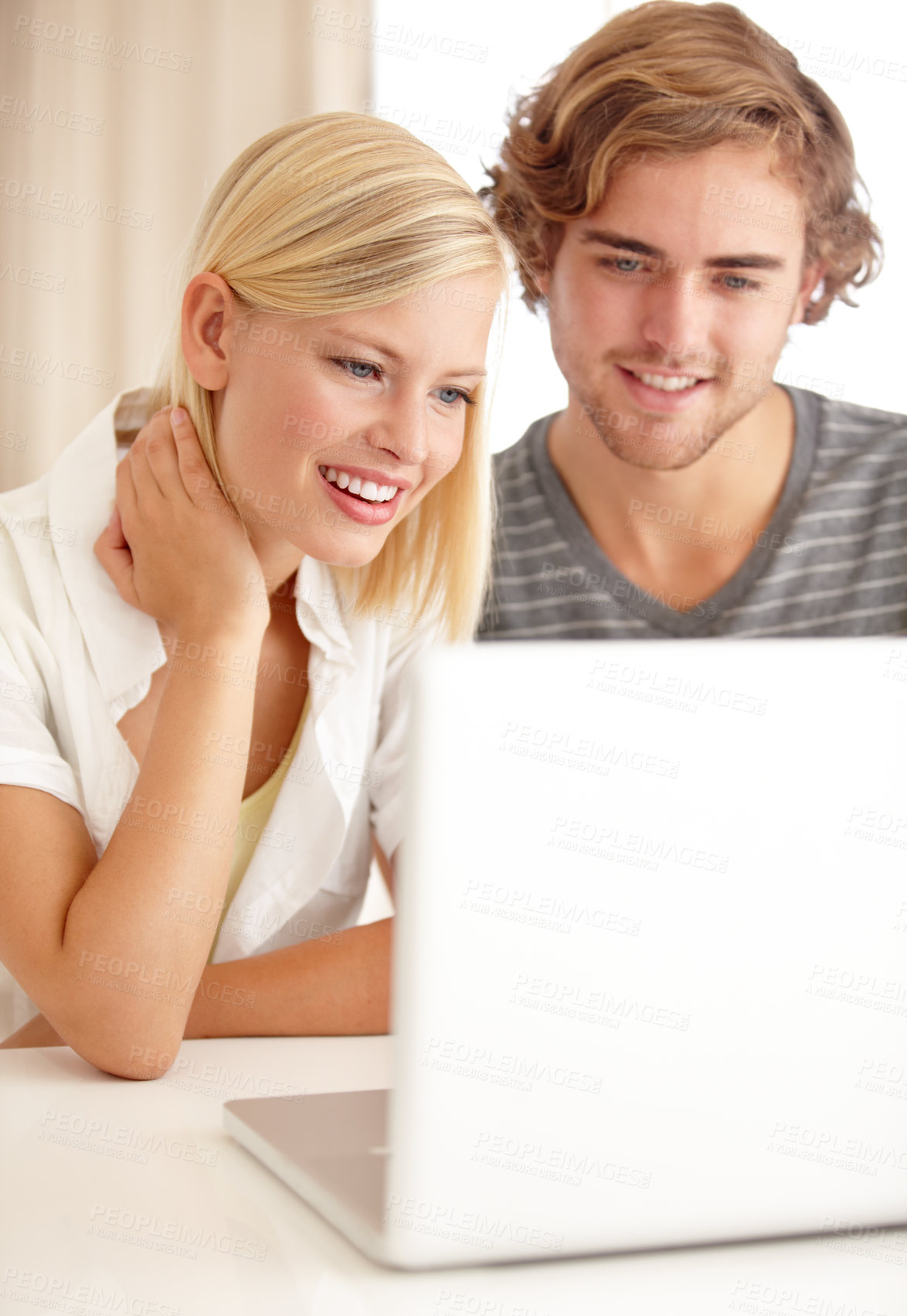 Buy stock photo A happy young couple using a laptop to browse the net