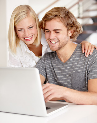 Buy stock photo A young couple using a laptop indoors