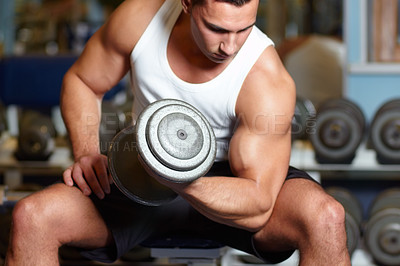 Buy stock photo A muscular young man working out in the gym