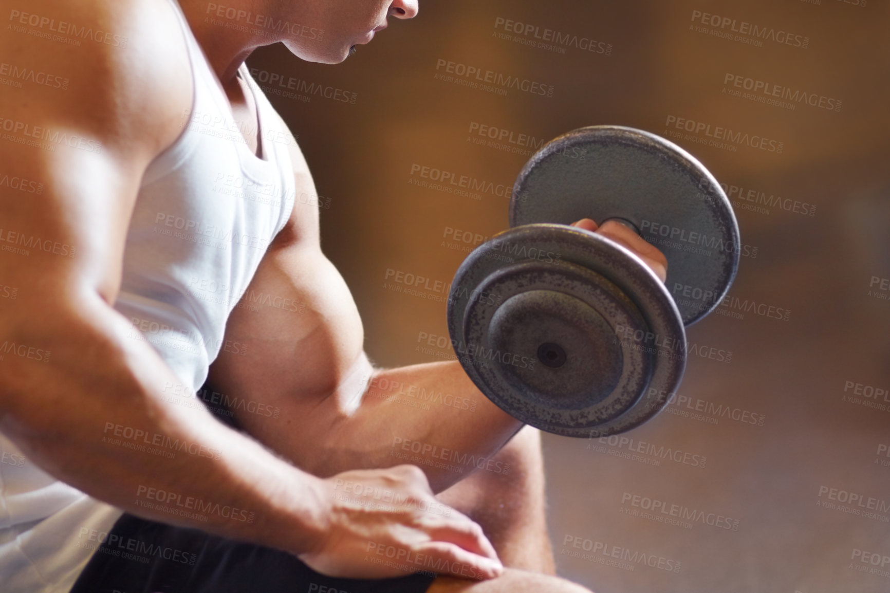 Buy stock photo Cropped shot of a muscular young man working out in the gym
