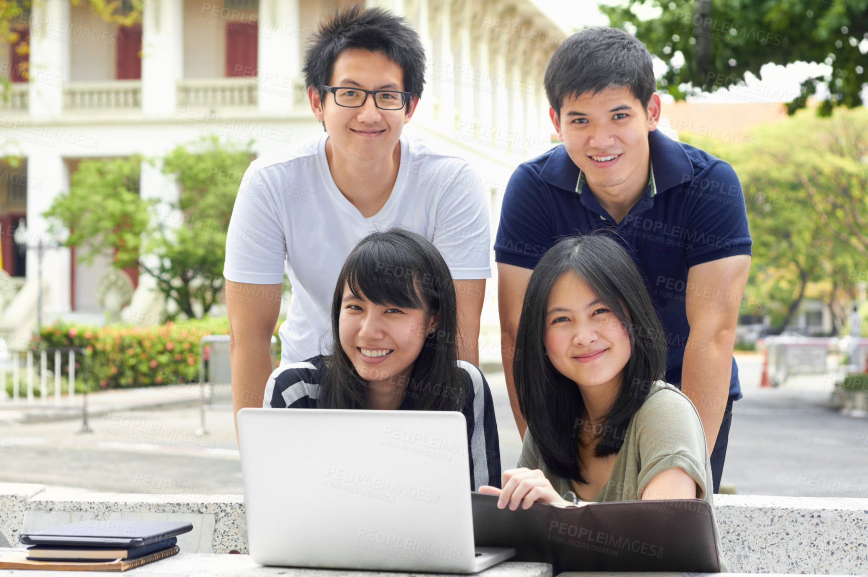 Buy stock photo Four young students sharing a laptop