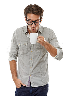 Buy stock photo A handsome young man blowing on a hot cup of coffee