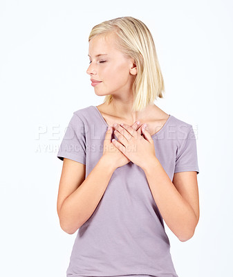 Buy stock photo Peace, calm or breathing and a woman in studio isolated on a white background with her hands on her chest. Quiet, relax and zen with an attractive young female posing on blank space for wellness