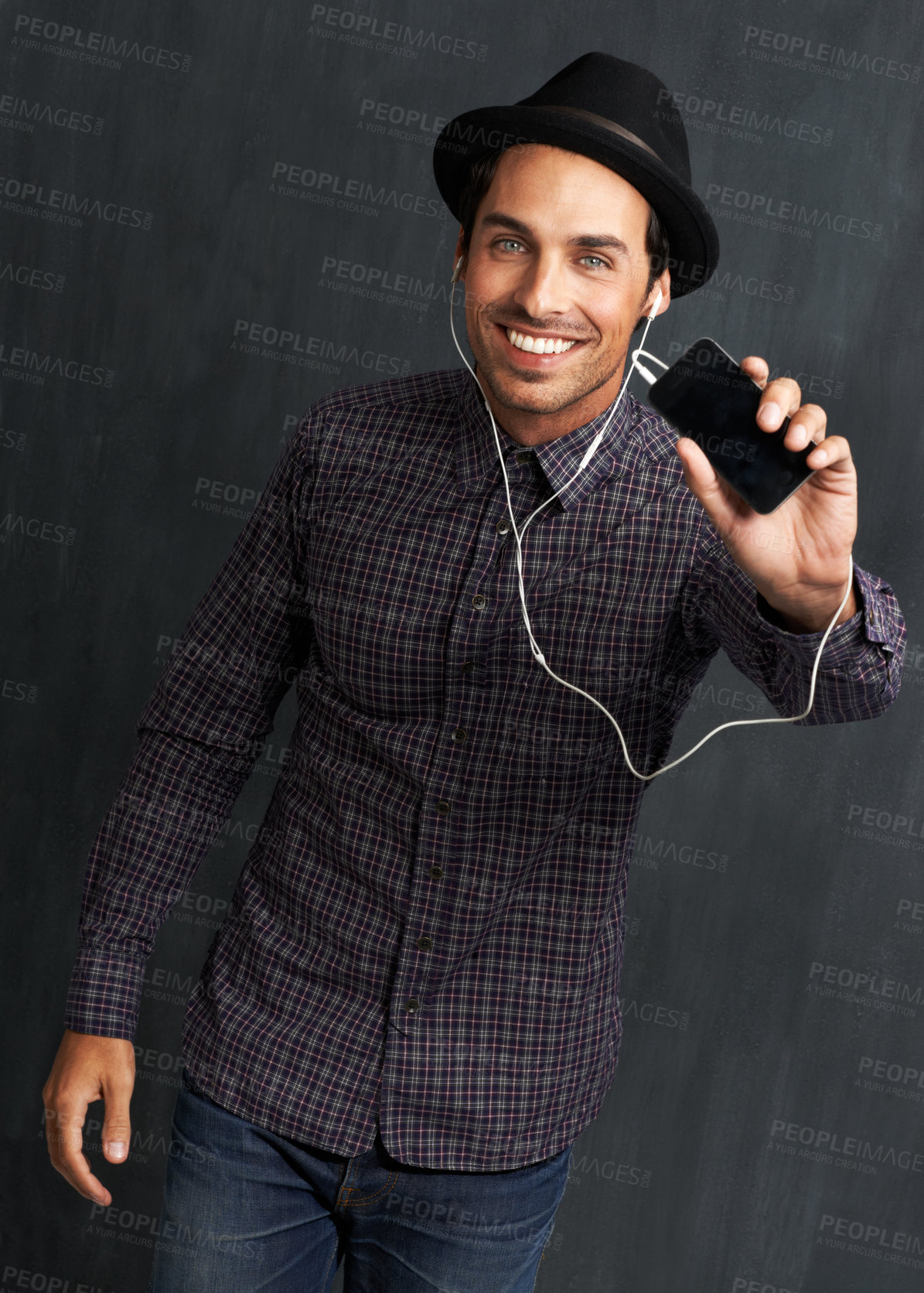 Buy stock photo Fashion, music and portrait of man on gray background with trendy style, clothes and casual outfit. Smile, handsome and face of person with cellphone for listening to audio, radio and song playlist