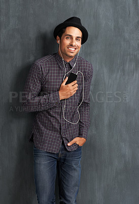 Buy stock photo Happy, music and portrait of man on gray background with trendy style, clothes and casual outfit. Fashion, handsome and face of person with cellphone for listening to audio, radio and song playlist