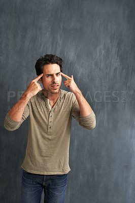Buy stock photo Annoyed, thinking and portrait of man by a wall with doubt, moody and angry facial expression. Upset, question and young male person from Canada with confused face pointing to head by gray background