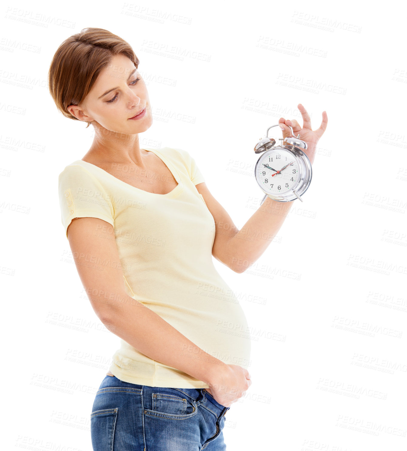 Buy stock photo Pregnancy, alarm clock and young woman in studio holding her stomach waiting for the birth of her baby. Maternity, prenatal care and pregnant female model with time clock isolated by white background