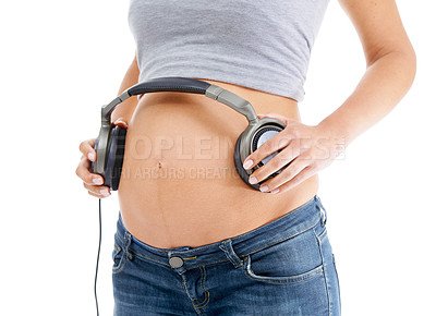 Buy stock photo Hands, headphones and pregnant stomach in studio with woman by white background for wellness, relax and baby. Pregnancy music, streaming and isolated pregnant woman with audio on abdomen for health