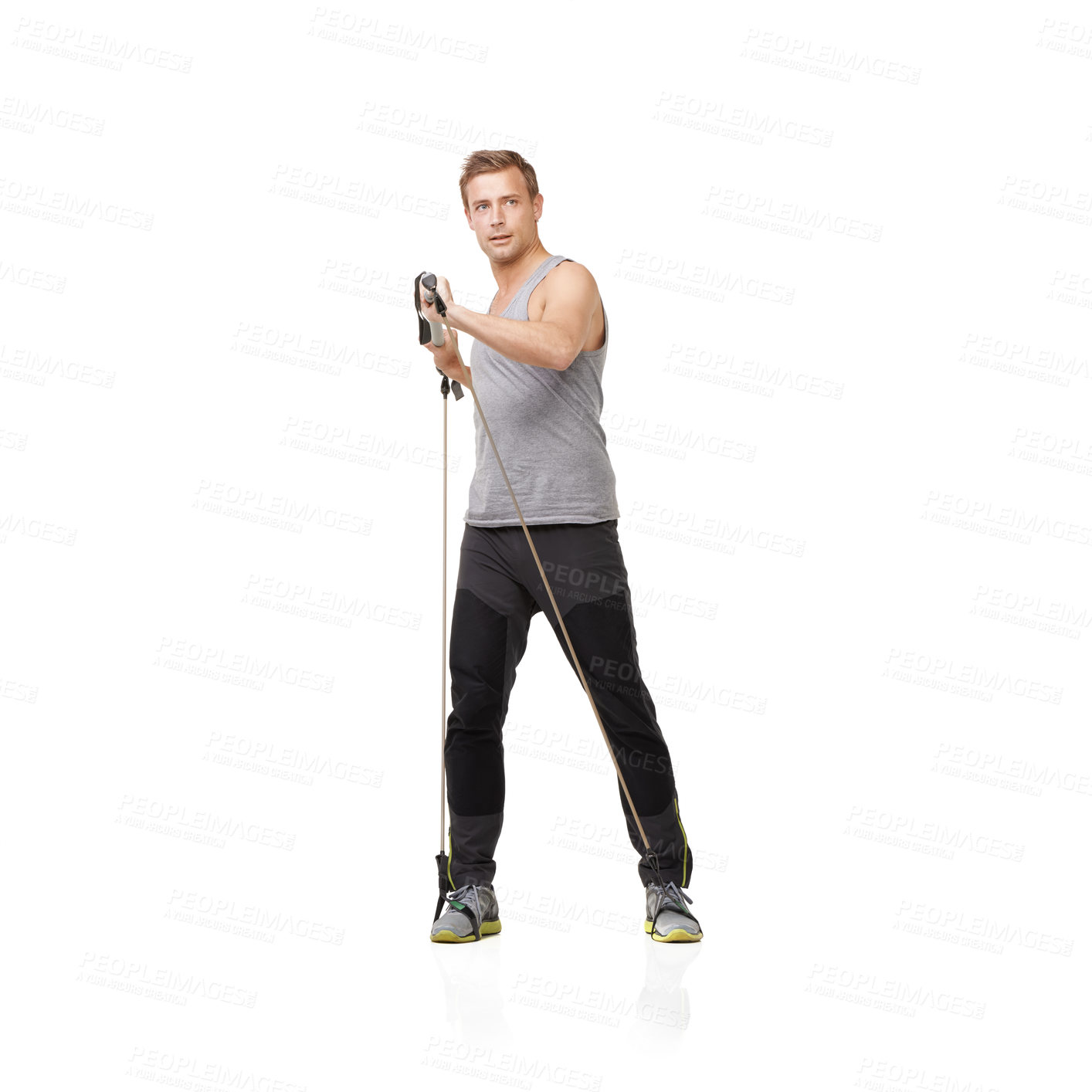 Buy stock photo A young man using a resistance band to tone his body