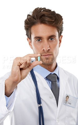 Buy stock photo Studio portrait of a serious-looking young doctor holding a pill up to the camera