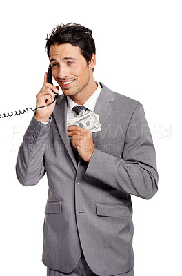 Buy stock photo An unethical businessman shoving a wad of cash into his jacket pocket while on a telephone