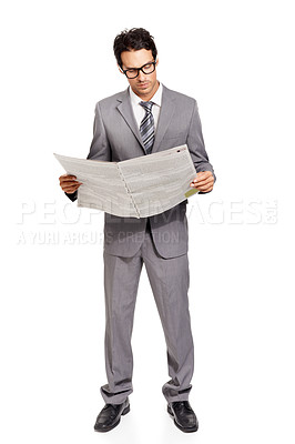 Buy stock photo A handsome young financier catching up on the latest stock market news